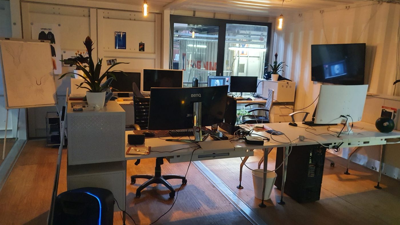 a room with computers and a plant