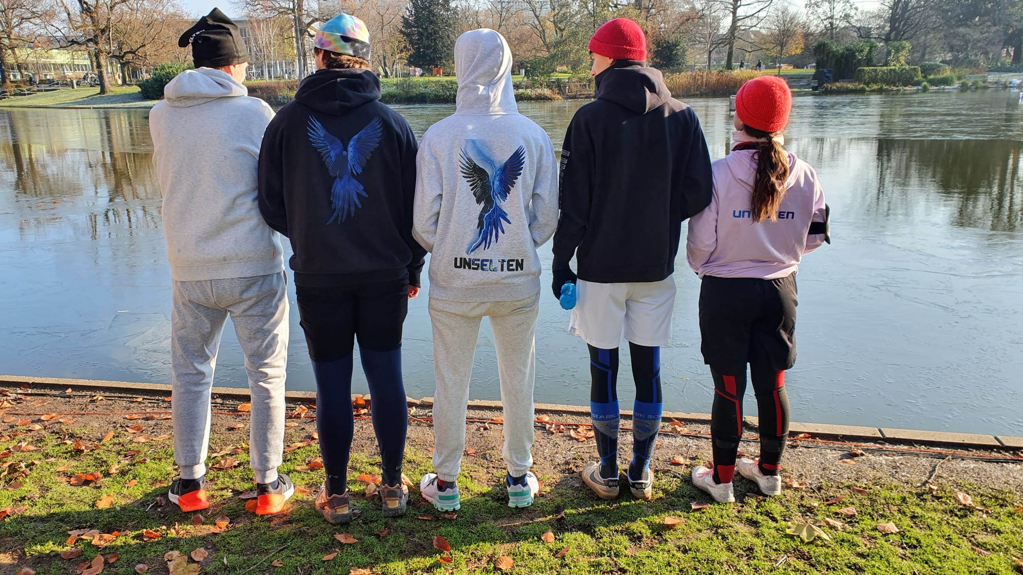 a group of people standing by a lake