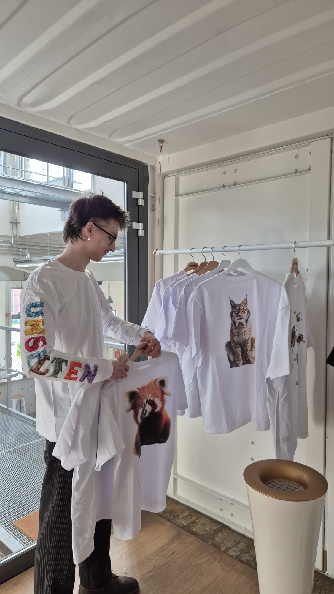 a man holding a shirt with a picture of an animal on it
